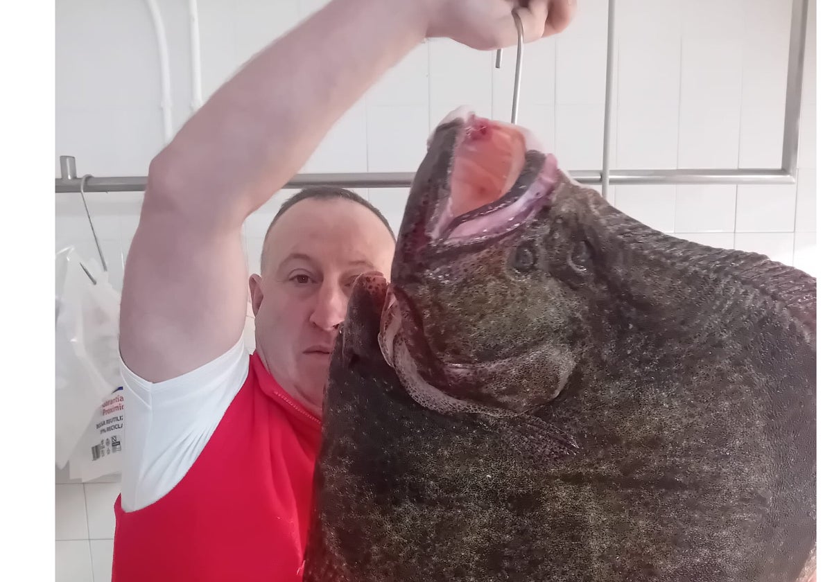 Pedro exhibe el rodaballo de 14,5 kilos en el Mercado del Sur gijonés.