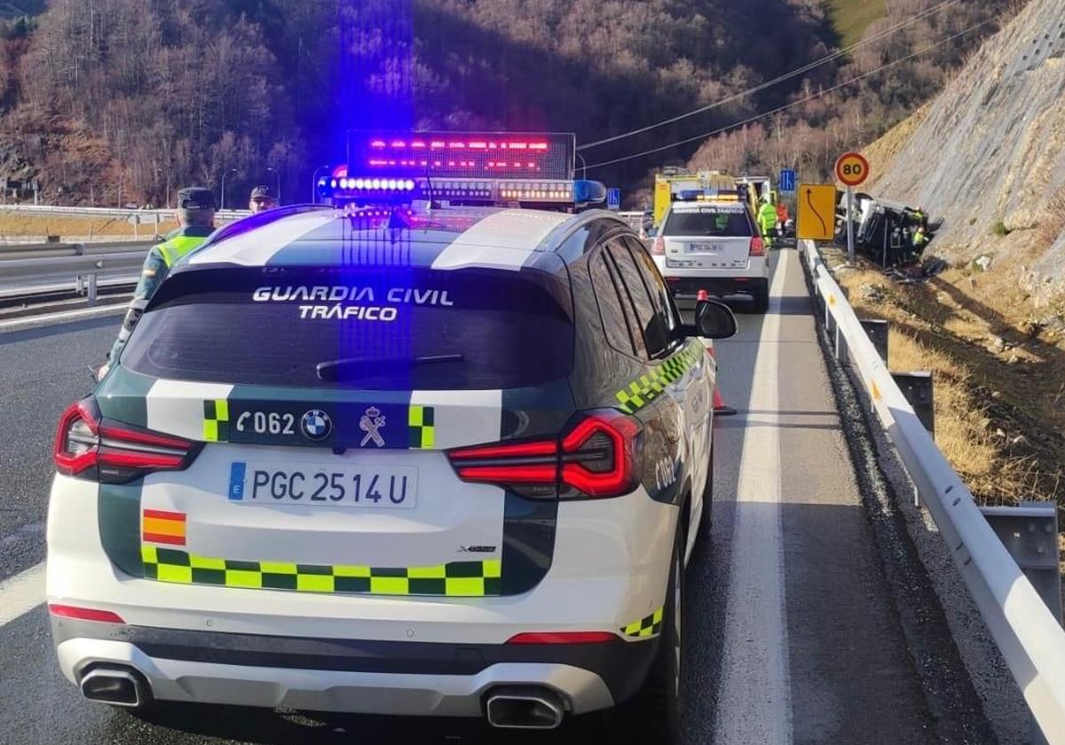 Dos patrullas de la Guardia Civil y el camión accidentado, al fondo.
