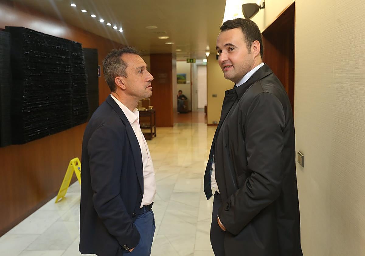 Ovidio Zapico, consejero de Ordenación del Territorio del Principado y coordinador de IU, y Guillermo Peláez, consejero de Hacienda, conversando en los pasillos de la Junta General.
