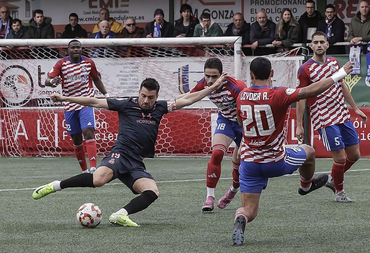 Natalio, capitán del Real Avilés, se dispone a rematar entre Leyder y Mateo Arellano en la primera gran ocasión de gol del partido para los blanquiazules.