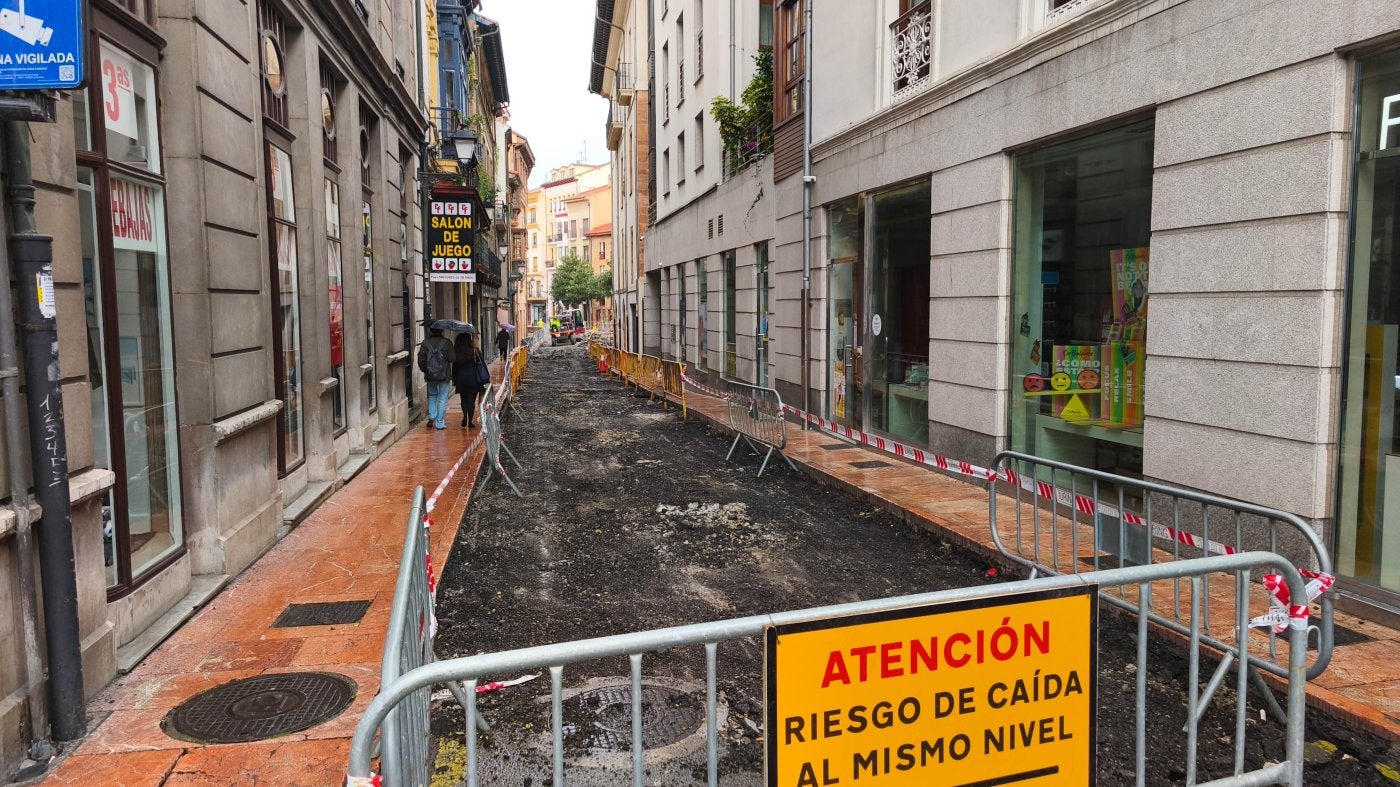 En primer término, el cartel que alerta del riesgo de caída en la calle Pozos de Oviedo.