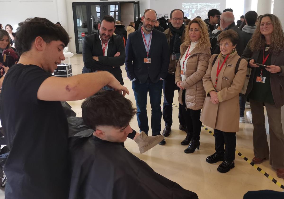 Uno de los alumnos del ciclo de Peluquería del instituto Batán de Mieres hace una demostración en la feria de Formación Profesional del Caudal.