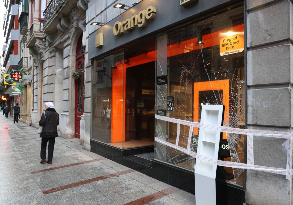 Estado en el que quedó la luna de la tienda asaltada en la calle Corrida de Gijón.