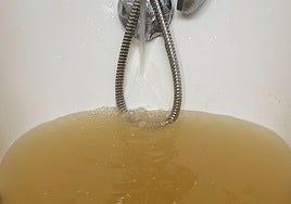 Agua acumulada en una bañera de Pravia, de color ocre.