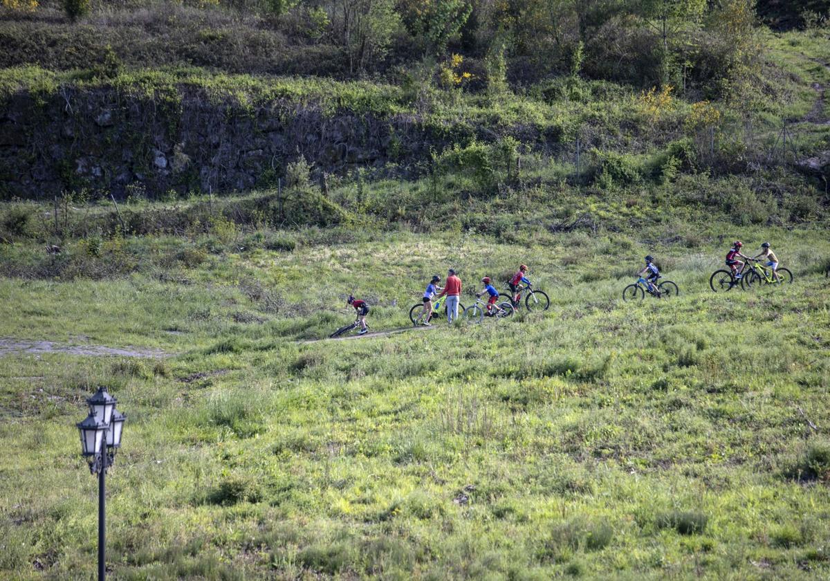 Un grupo de niños anda en bicicleta por las zona donde estaba previsto edificar la ciudad deportiva del Real Oviedo.