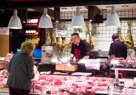 Una clienta compra carne en la charcutería de un supermercado.
