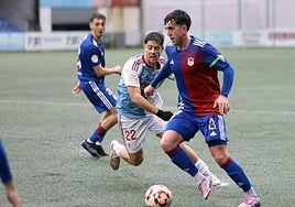 Sergio Orviz controla un balón sobre un terreno de juego del Ganzábal visiblemente encharcado.
