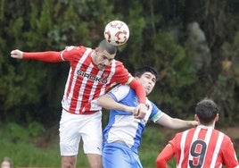 El rojiblanco Aarón se adelanta en la pugna por un balón en el campo número 1 de Mareo. Los dos equipos lucieron un brazalete de color verde con motivo del Día contra el Cáncer, el 4 de febrero.
