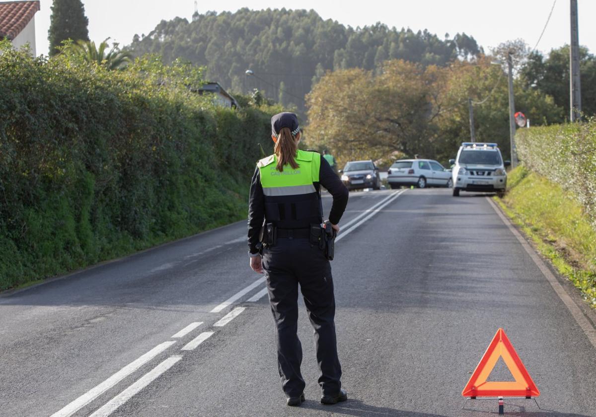 Una agente de la Policía de Castrillón señaliza un accidente.