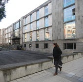 Una mujer camina por delante de la Escuela de Minas en l a calle Independencia.