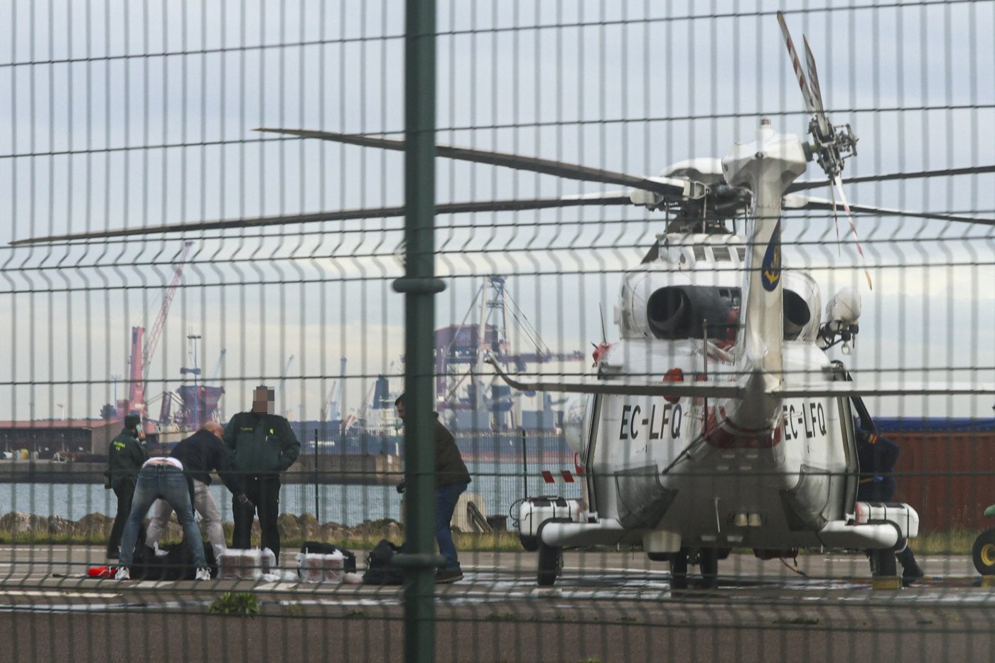 La Guardia Civil revisa en El Musel los paquetes de droga hallados flotando tras el rescate de los náufragos.