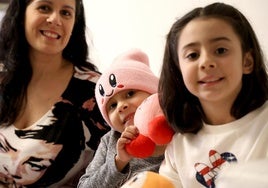 Martina, entre su madre y su hermana Sofía, en el piso que la asociación Galbán ha puesto a su disposición cerca del Hospital Central de Asturias.