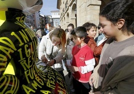 La piloto Alba Vázquez firma autógrafos en la Plaza de España.