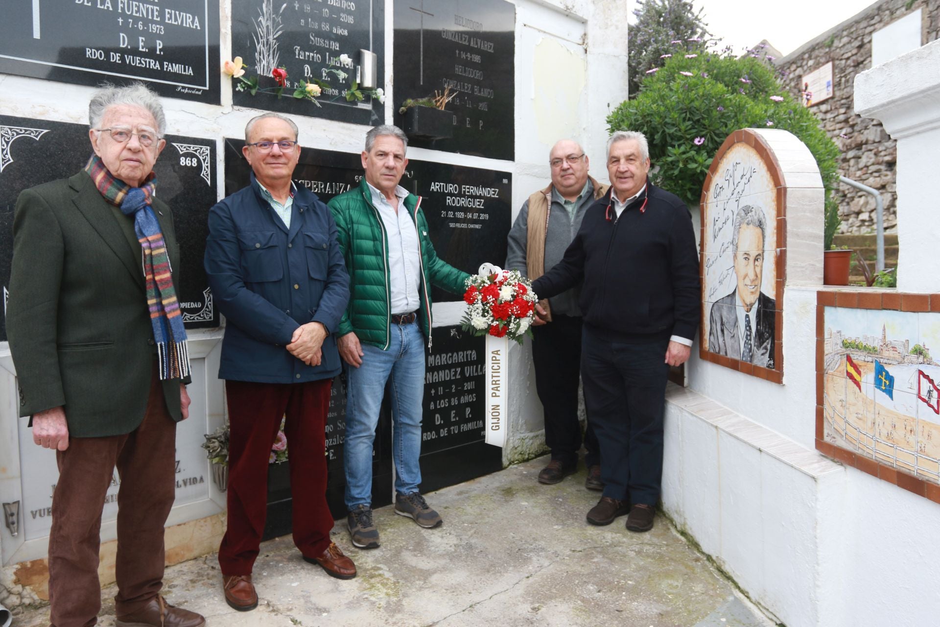 Janel Cuesta, José Luis Villar, Juan García Peón, Alberto Estrada y Manuel Machargo, junto a la tumba de Arturo Fernández, en Ceares, con un ramo de flores de Gijón Participa.