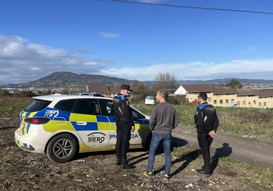 El alcalde de Siero (centro) conversa con dos agentes municipales al lado del poblado de la Sierra de Granda, este sábado.