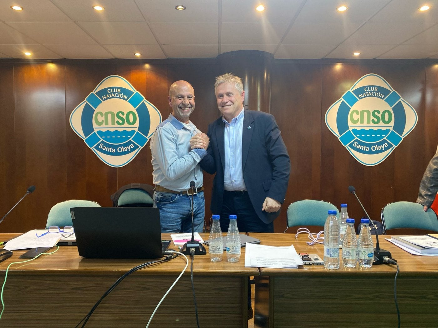 Gonzalo González Méndez y José Enrique Plaza, desde ayer presente y pasado del Santa Olaya, se estrechan la mano durante la asamblea.