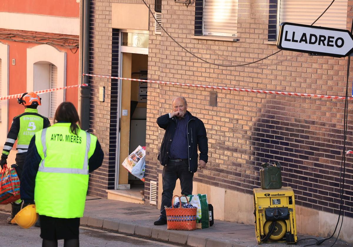 Un hombre, con varias bolsas tras poder acceder a su vivienda, cerca de donde ocurrió la explosión en Mieres.