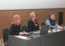 Ana Ceballos, profesora de Geografía e Historia; Milagros Madiedo, exdirectora del IES Jovellanos; e Hilario Mañanes, presidente de la Asociación de Antiguos Alumnos, en el salón de actos de la Escuela de Comercio.