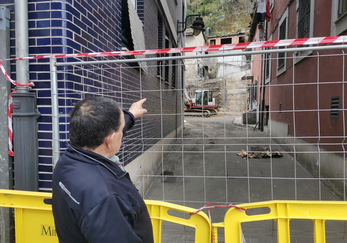 Lalo Fernández señala su casa al otro lado de la valla que cierra la zona de la explosión, en el barrio de La Villa, Mieres.