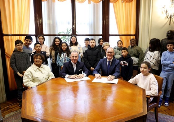 Pablo Junceda e Ignacio Vázquez, este lunes, en la firma del convenio acompañados de escolares