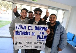 Jamín García y miembros de la familia Giurgiuveanu sostienen el cartel motivacional del barrio.