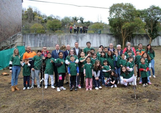 Foto de familia de los colegiales con el alcalde, Alfredo Canteli, en la zona donde se plantaron ayer los manzanos y perales en Tudela Veguín.