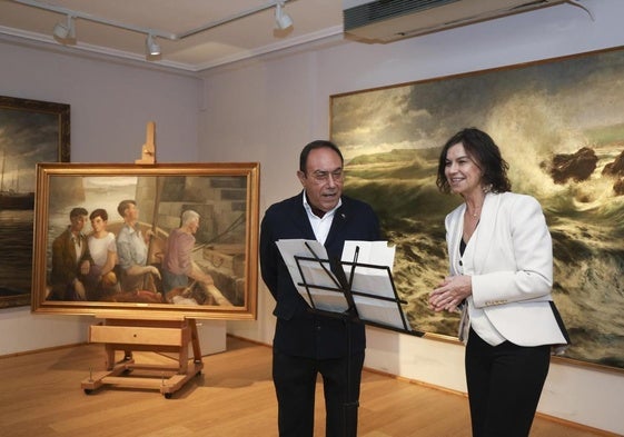 El pintor gijonés Jesús Gallego y la concejala de Cultura de Gijón, Montserrat López Moro, con el cuadro 'La primera marea'.