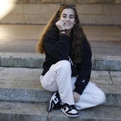 Laura Fuertes sonríe sentada desde uno de los escalones del patio de la Universidad Laboral.