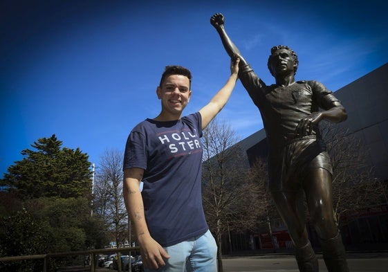 El gijonés Senén Morán choca la mano con la estatua de su ídolo, Quini, frente al Molinón .