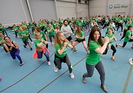 Participantes en el 'Green Zumba Solidario' bailando por una causa solidaria en el polideportivo del Club Natación Santa Olaya.