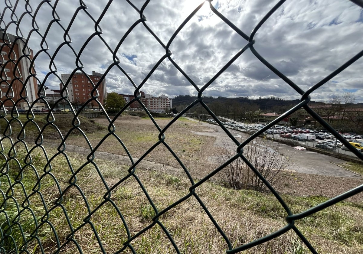 Tras la valla, la parcela que ocupaba el antiguo matadero de Pola de Siero, donde irán el nuevo parque y el aparcamiento en altura.