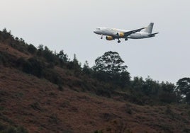 Un avión sobrevuela terrenos en torno al aeropuerto.
