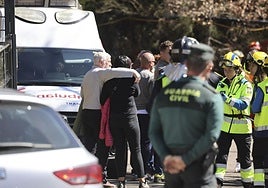 En primer plano, un agente de la Guardia Civil. Al fondo, sanitarios atienden a los familiares de las víctimas de la explosión en la mina de Cerredo.