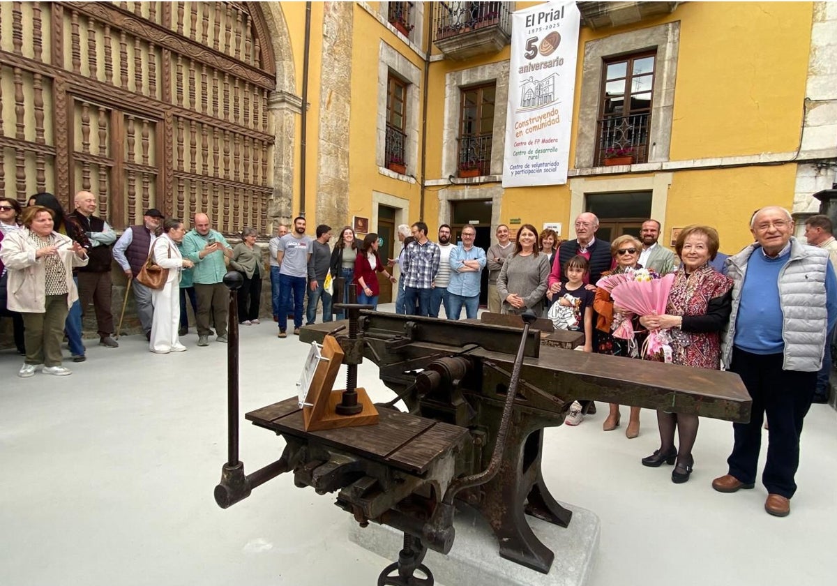 El equipo formativo de El Prial, con el alcalde, varios alumnos, exalumnos y padres, y las hermanas Ana María y Raquel Sánchez, que donaron al centro esta máquina combinada de carpintería de 1949, del taller de su padre, Enrique Sánchez Martín.