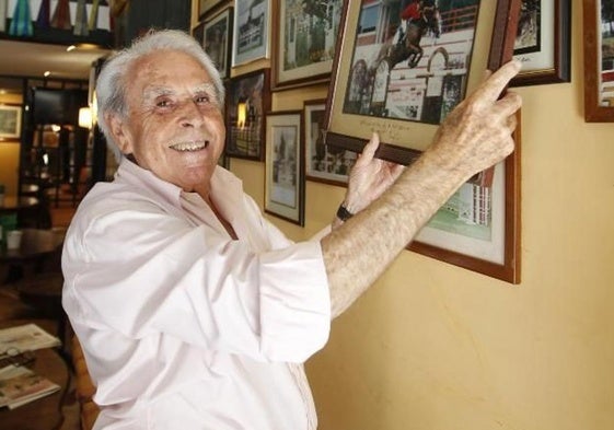 José Manuel Buznego, mostrando las fotos que coleccionaba en su bar de La Arena, en 2019.