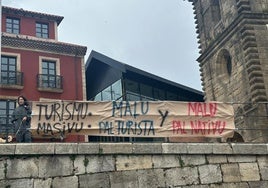 Cartel contra el turismo masivo en el barrio de Cimavilla, en Gijón.