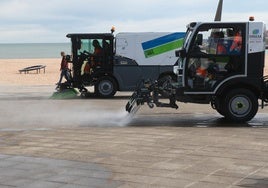 Vehículos de Emulsa, en el paseo de la playa de Poniente de Gijón.