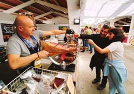 Expositor y asistentes de una edición anterior de la Feria de Muestras de Tineo.