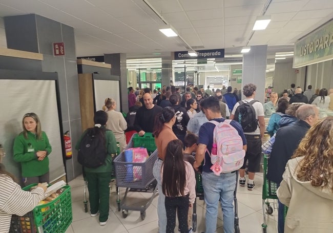 Largas colas en torno a las dos de la tarde en un supermercado de Gijón.