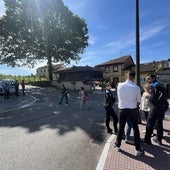 A la derecha, vecinos contra la tala conversan con agentes de la Policía Local, con el roble afectado por la polémica al fondo.