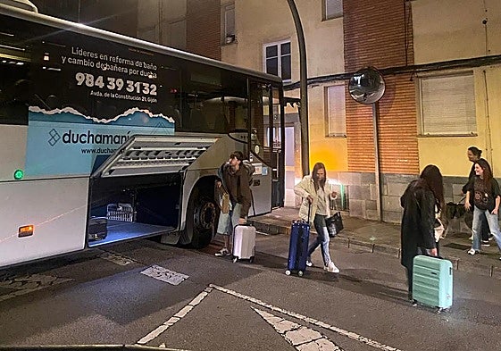 Los pasajeros salen del autobús y recogen las maletas tras el atasco del conductor.