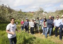 El agricultor Francisco Foncueva explica la vecería de la manzana al grupo de visitantes
