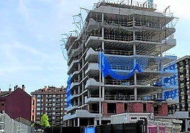 La calle Diario El Comercio de Gijón, estrechada por las obras de las nuevas promociones, y edificio El Comercio, que sube ya siete plantas.