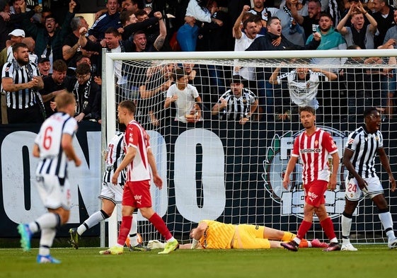 Los jugadores del Sporting de Gijón Maras y Kevin ven cómo celebran uno de los goles los jugadores del Castellón, mientras Yáñez observa desde el suelo el balón dentro de su portería.