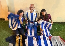 Carlos Díaz posa en su domicilio de Jerez junto a sus hijas Marta y Carla y su colección de camisetas del Avilés.