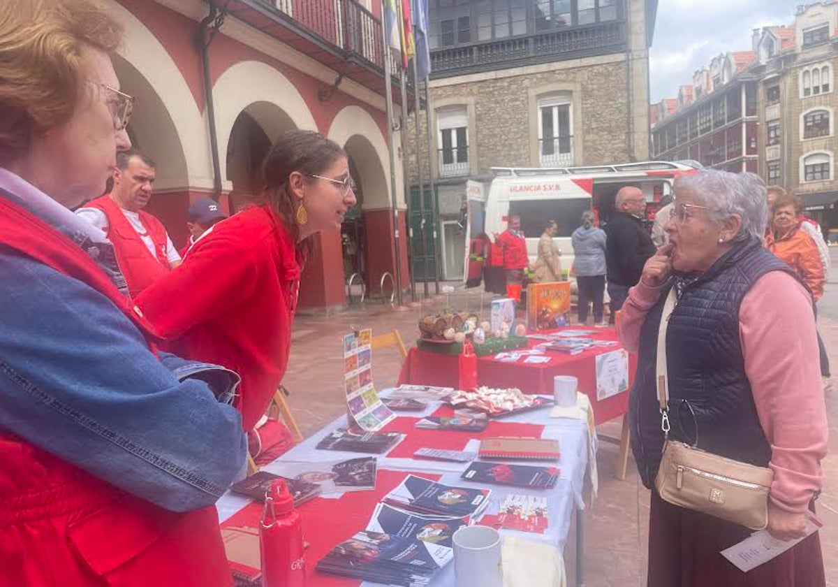 Voluntarios de la asamblea de Cruz Roja de Langreo informando a sus vecinos de sus proyectos para combatir la soledad no deseada.