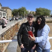 Una pareja se hace una foto en el Muro de San Lorenzo con la iglesia de San Pedro de fondo.