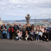 Los vecinos de El Muselín reunidos frente a la sede vecinal del barrio, en el fondo de la foto, el puerto de El Musel.