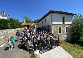 Los vecinos de Asiegu y el coro Voces Mansoleas de Pimiango, ante la escuela centenaria del pueblo cabraliego.