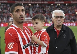 Cote, con su hijo Nel en brazos, observa las imágenes del videomarcador junto a su 'güelu' Pepe, al término del partido frente al Cartagena.